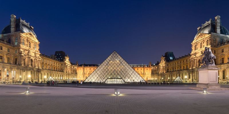 The Louvre pyramid lit up at dusk